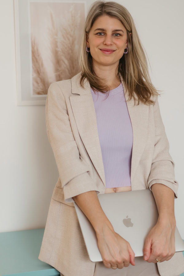 Finja Wolkenstein - Gründerin von Wolkenstein Webdesign. Sie lächelt in die Kamera und hat ihren Laptop in der Hand.